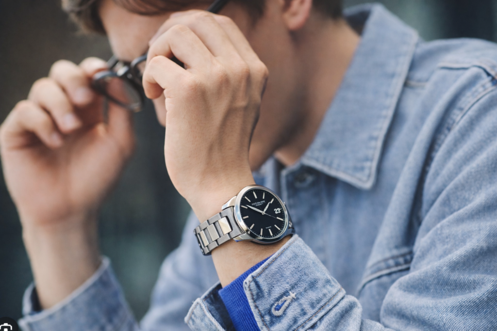 薄いデニムジャケットを着た男性がセイコーセレクションSBPX145の黒文字盤ステンレス腕時計を着用しているカジュアルスタイル